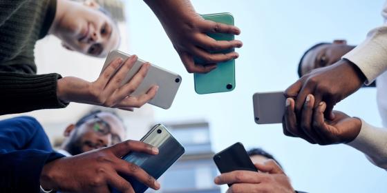 The image shows people with smartphones in their hands.
