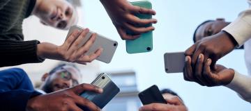 The image shows people with smartphones in their hands.