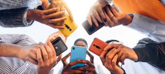 The image shows multiple people having mobile phones in their hands