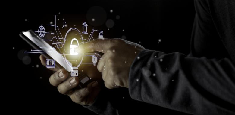 The image shows a person holding a mobile phone in the hand.