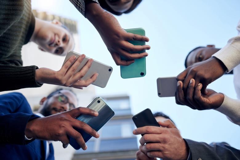 The image shows people with smartphones in their hands.