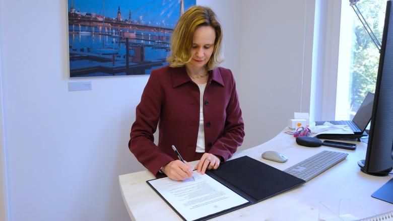 The image shows the Director of the BEREC Office, Verena Weber, signing the Green Charter.