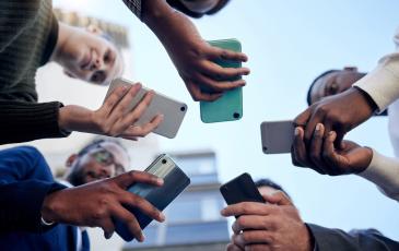 The image shows people with smartphones in their hands.