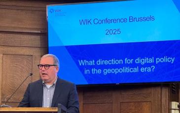 The image shows BEREC Chair Robert Mourik (ComReg, Ireland) during his keynote at the WIK Conference 2025.