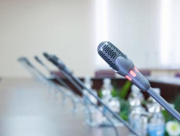 The images shows multiple microphones installed within a long table