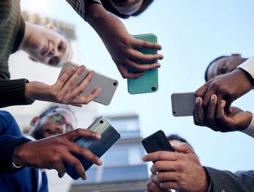 The image shows people with smartphones in their hands.